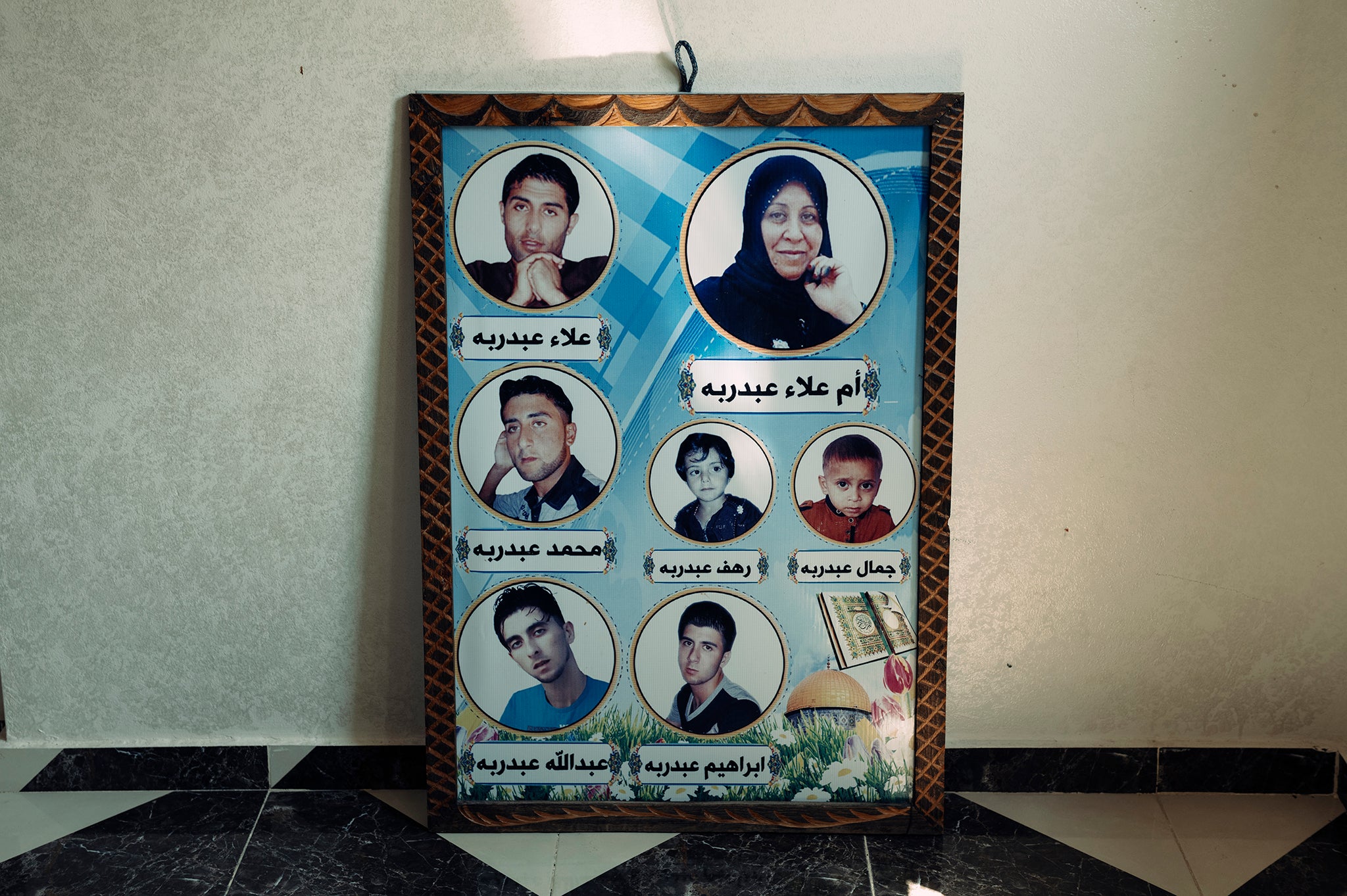 A framed poster in Baraka’s family home, showing the faces and names of some of the family members who were killed while seeking shelter