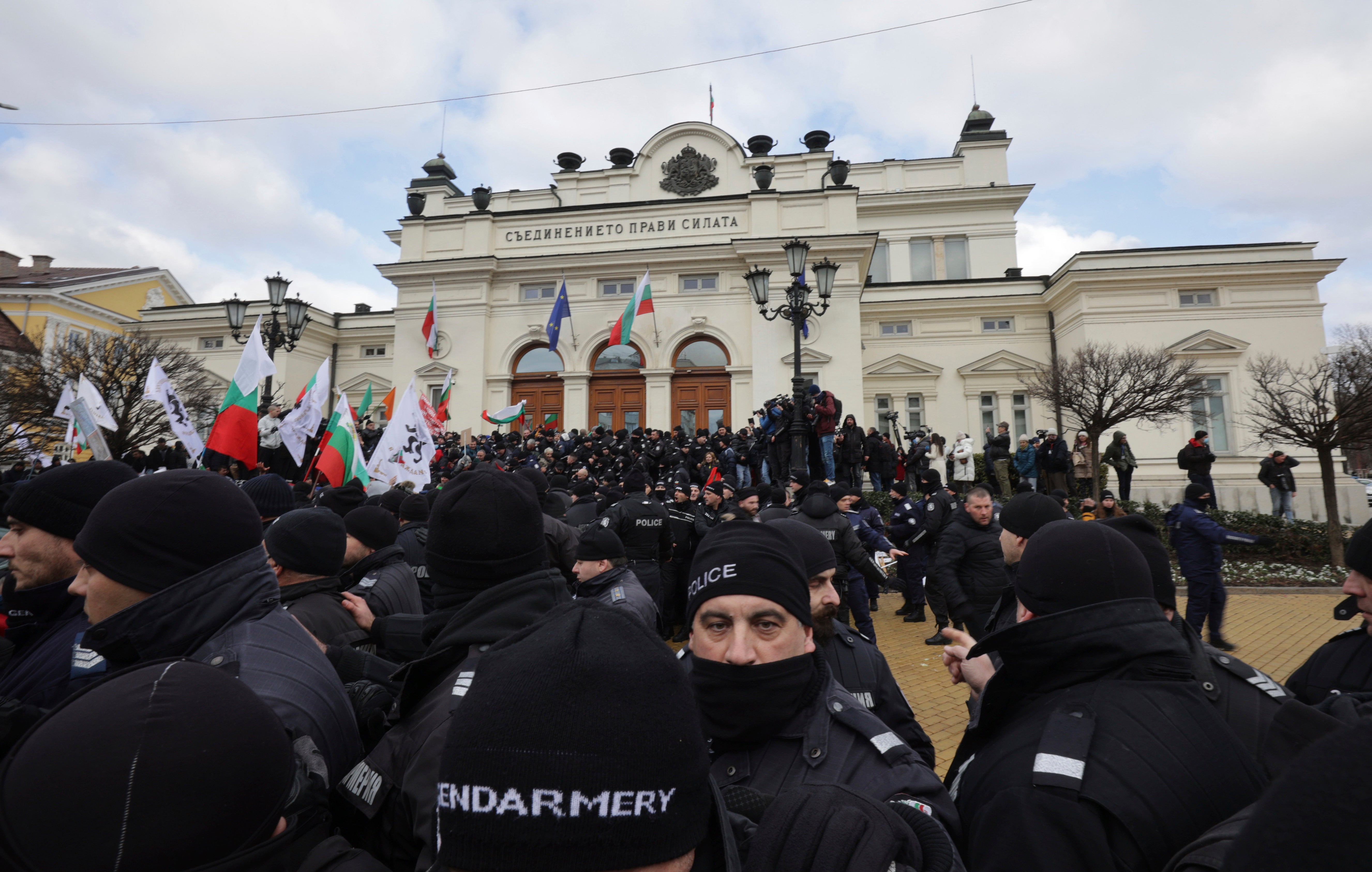 Police officers line up as they try to keep protesters away from the Bulgarian parliament building in Sofia on Wednesday