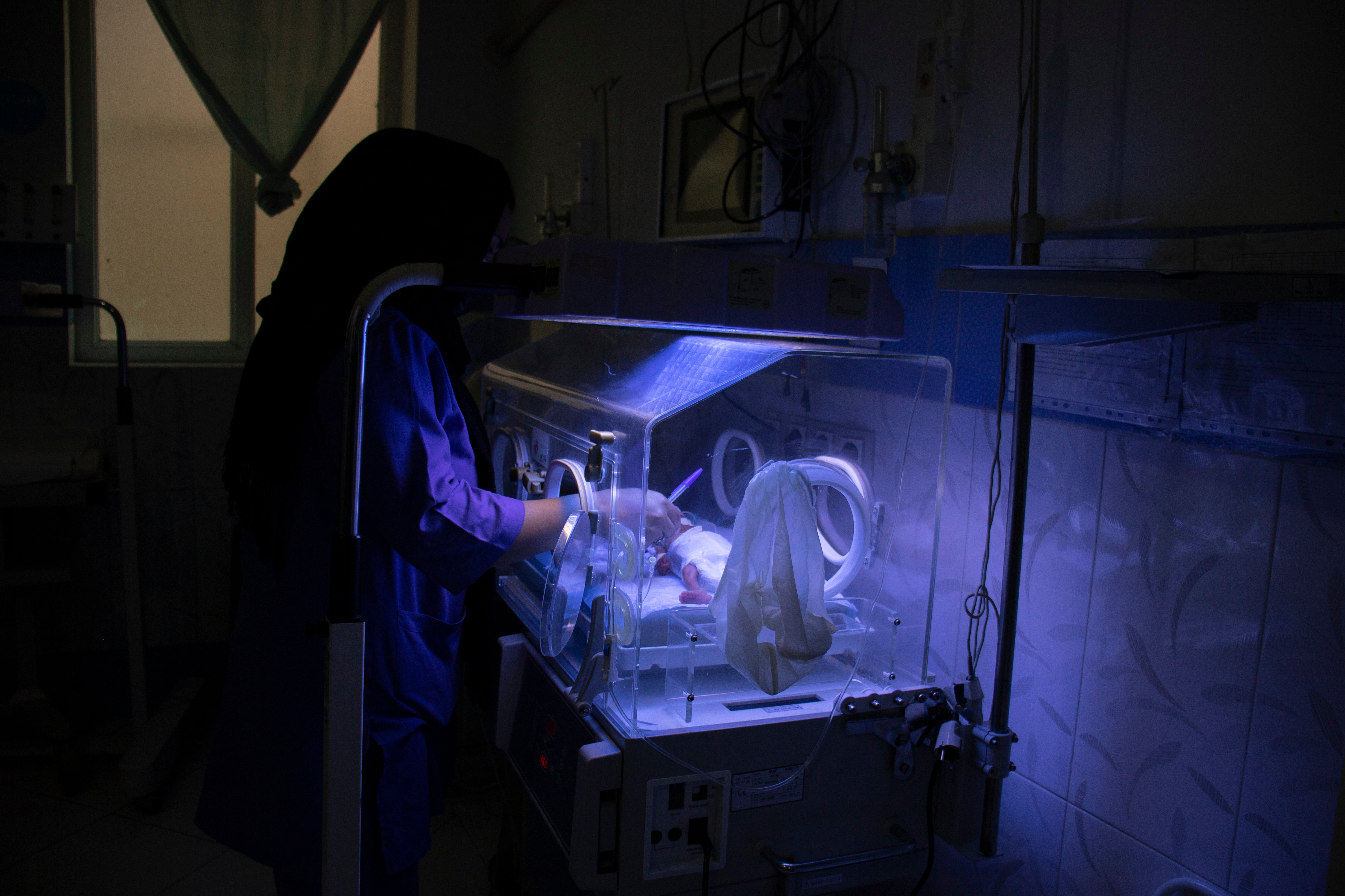 A nurse tends a baby in an incubator