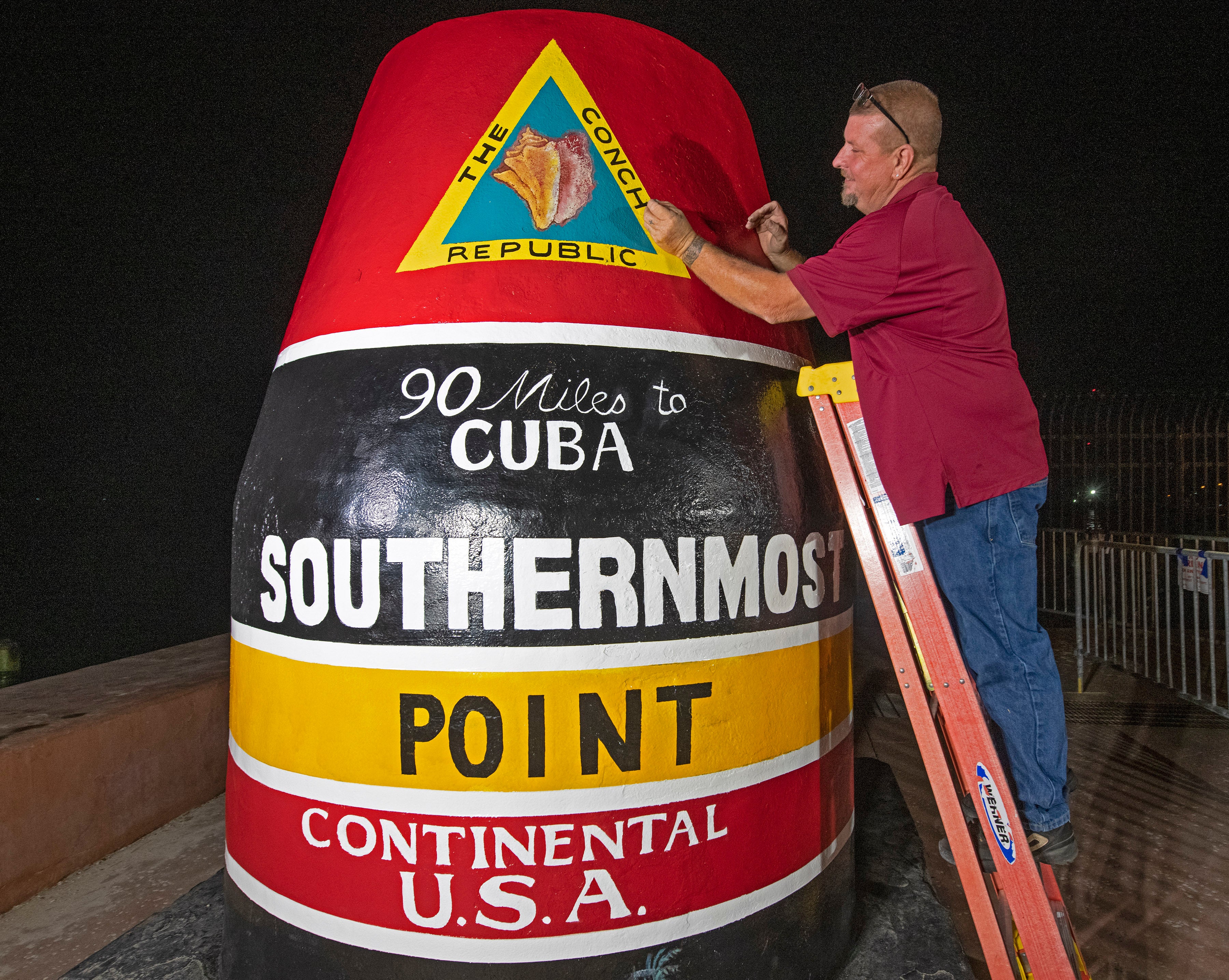 <p>In this photo provided by the Florida Keys News Bureau, Key West Public Works employee Paul Cassidy puts finishing touches on the Southernmost Point marker Thursday, Jan. 6, 2022, in Key West, Fla. </p>
