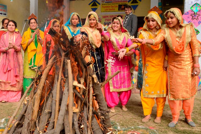 <p>Students wearing traditional Punjabi outfits perform a ritual around a bonfire to celebrate Lohri</p>