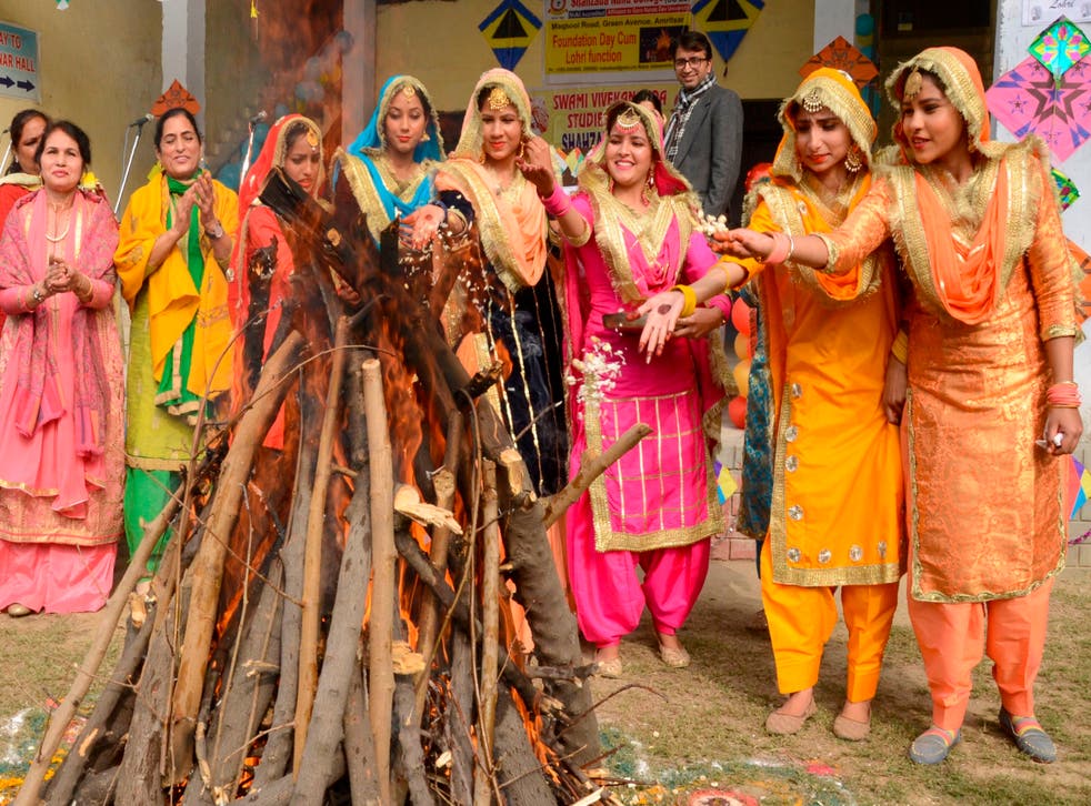 <p>Students wearing traditional Punjabi outfits perform a ritual around a bonfire to celebrate Lohri</p>