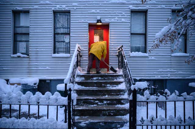 <p>A man shovels snow in Brooklyn, New York during the first snow storm of the season on January 7, 2022. More freezing weather is on the way for the East Coast this week</p>