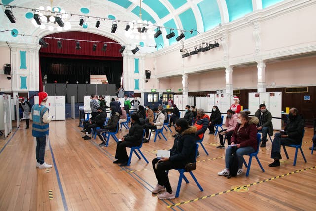 People wait to receive a Covid-19 vaccination booster at Redbridge Town Hall in Ilford, Essex (Gareth Fuller/PA)