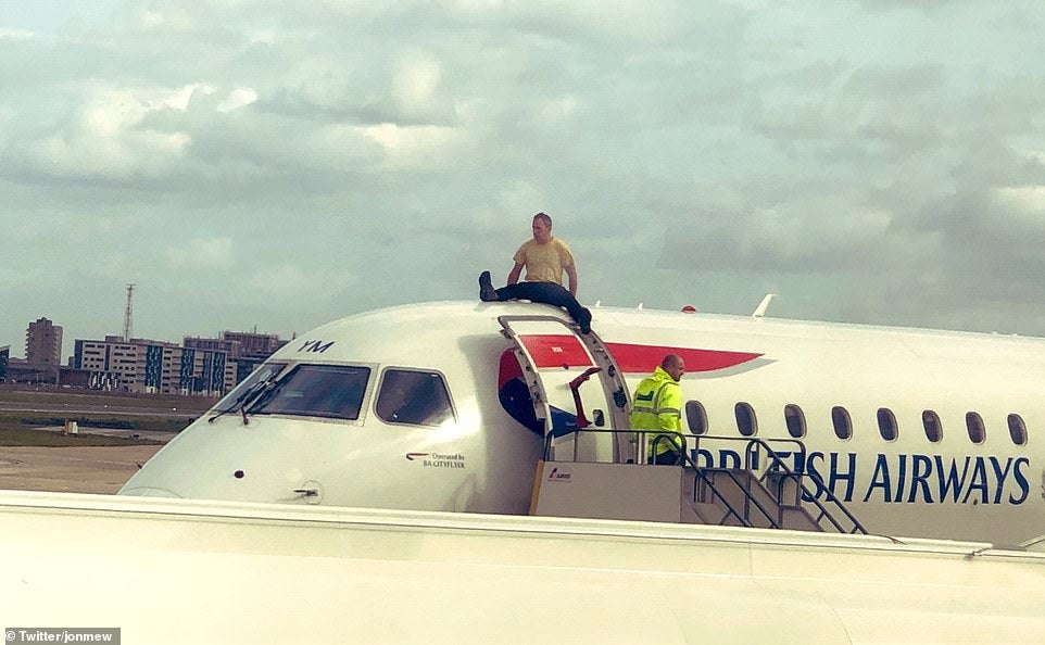 Extinction Rebellion activist James Brown on top of a plane on the morning of October 10 2019 during a protest against flying at London City Airport (Extinction Rebellion/PA)