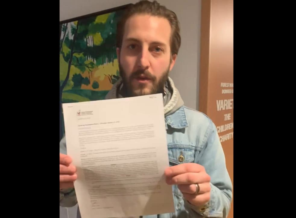 <p>Austin Fergason holds up a letter from the charity in a video posted on Facebook</p>