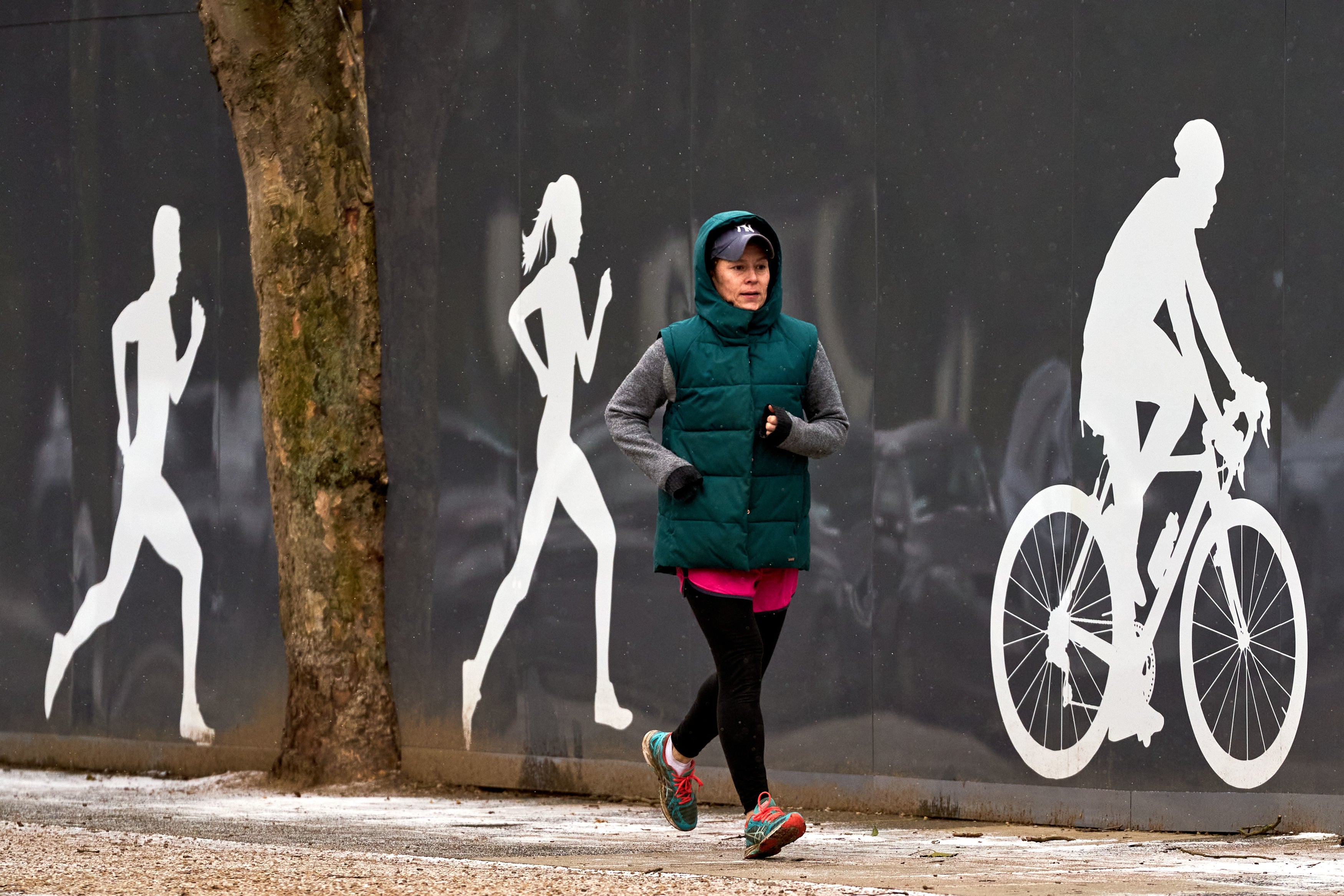 A runner wrapped up warm against freezing cold temperatures outside Richmond Park in London