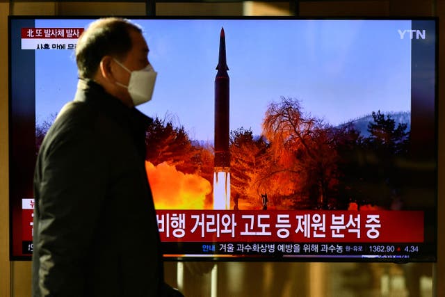 <p>A man walks past a video screen in Seoul showing footage of a North Korean missile test</p>