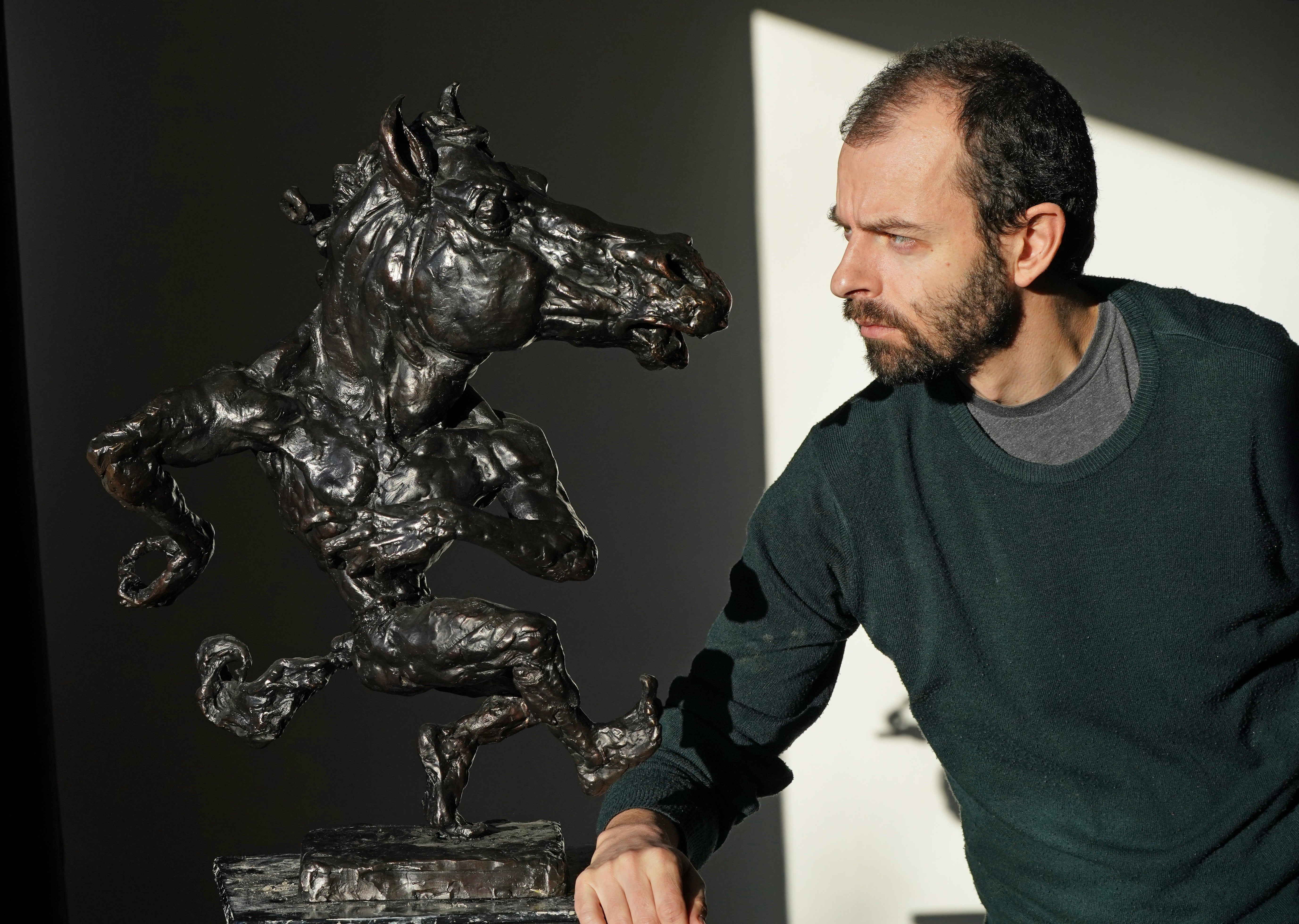 Sculptor Alan Harte with a miniature version of his puca statue (Niall Carson/PA)