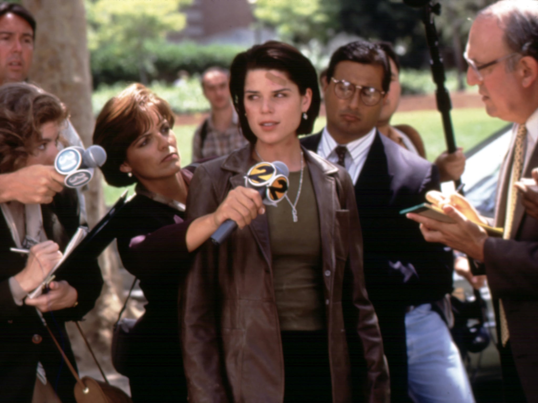 Neve Campbell’s Sidney is surrounded by reporters in ‘Scream 2'
