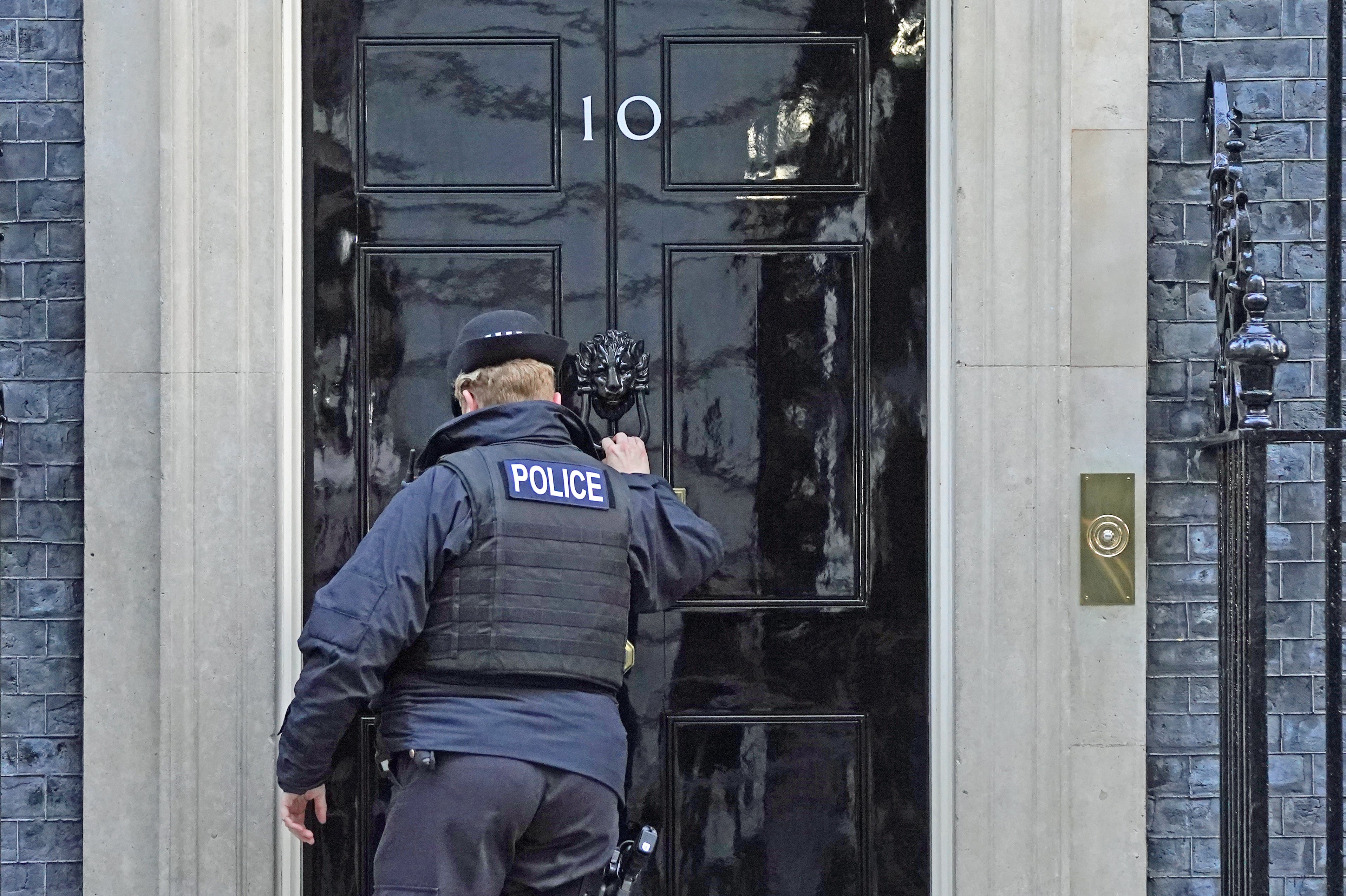 A police officer knocks on the door of the Prime Minister’s official residence in Downing Street (Stefan Rousseau/PA)