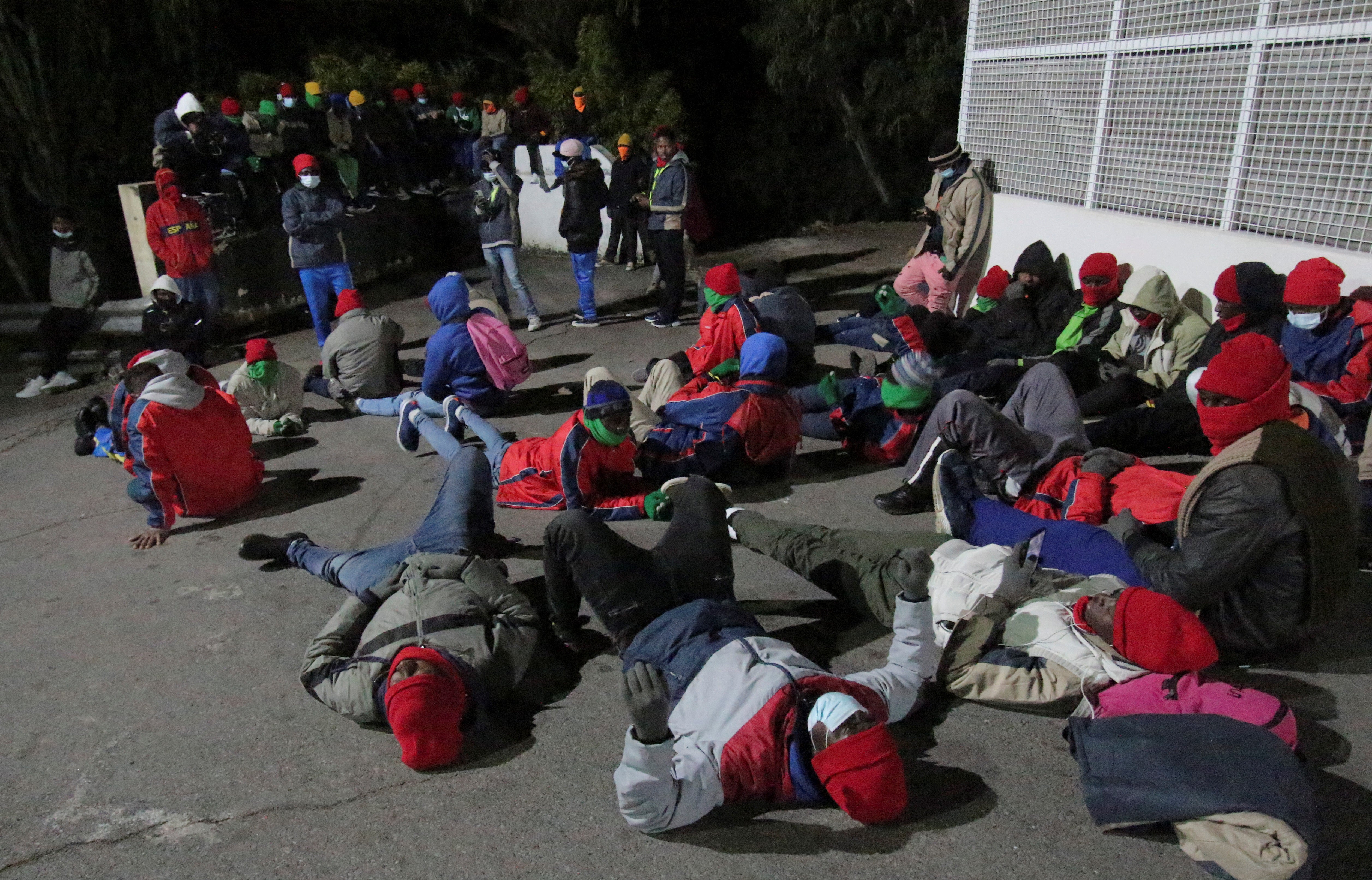 Migrants stage a sit-in protest outside a temporary migrant shelter in Ceuta