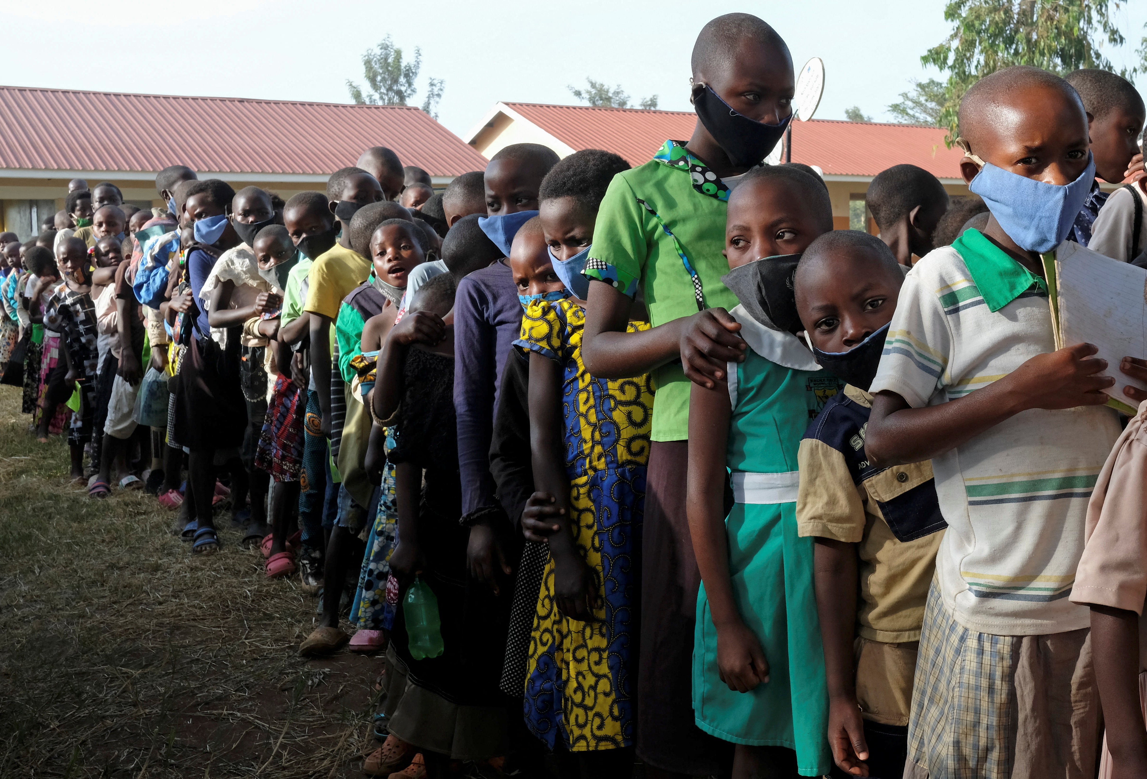 Pupils queue at the Sweswe primary school after schools reopened in Kyegegwa District