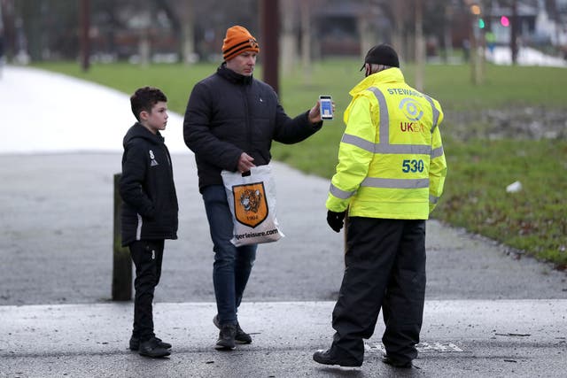 Fans show their Covid passports before an FA Cup match at the MKM Stadium, Hull (Richard Sellers/PA)