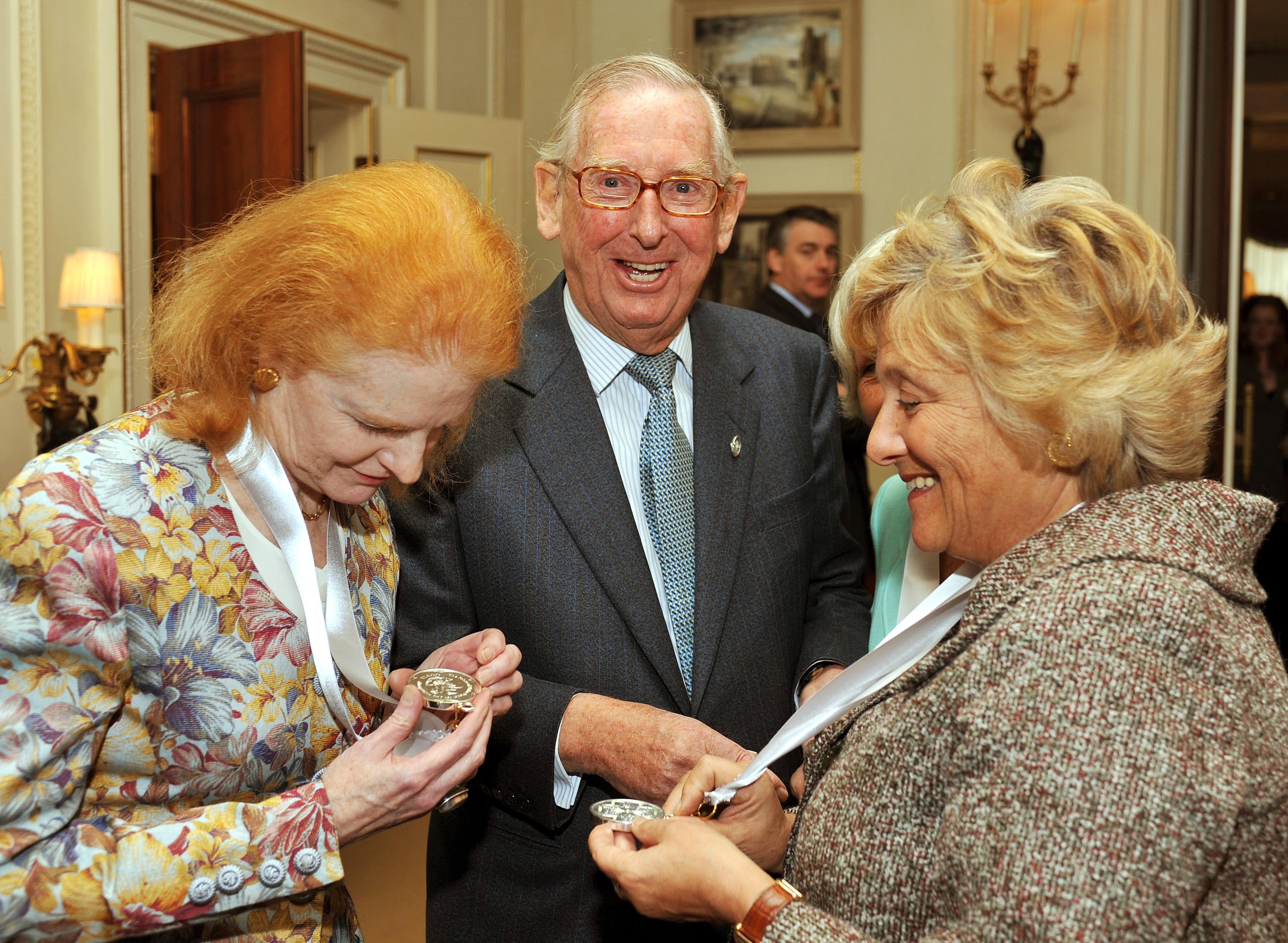 Lord Sainsbury laughs as Dr Carol Hogel CBE (left) and Dame Vivien Duffield CBE, study their Prince of Wales Medals for Arts Philanthropy at Clarence House in central London. (John Stillwell/PA)