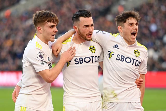 <p>Harrison (centre) celebrates with teammates Lewis Bate and Daniel James after scoring his third goal</p>
