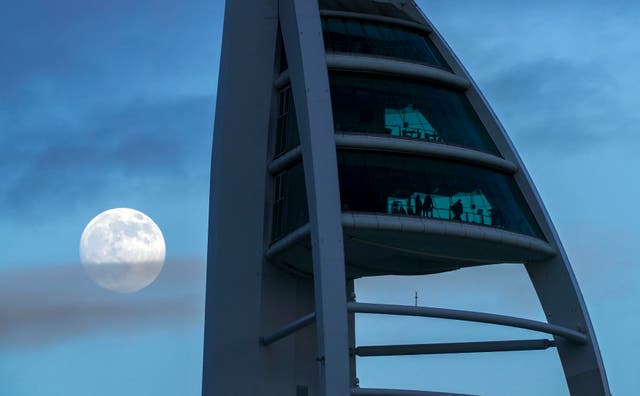 The moon rises above the Spinnaker Tower in Portsmouth, Hampshire