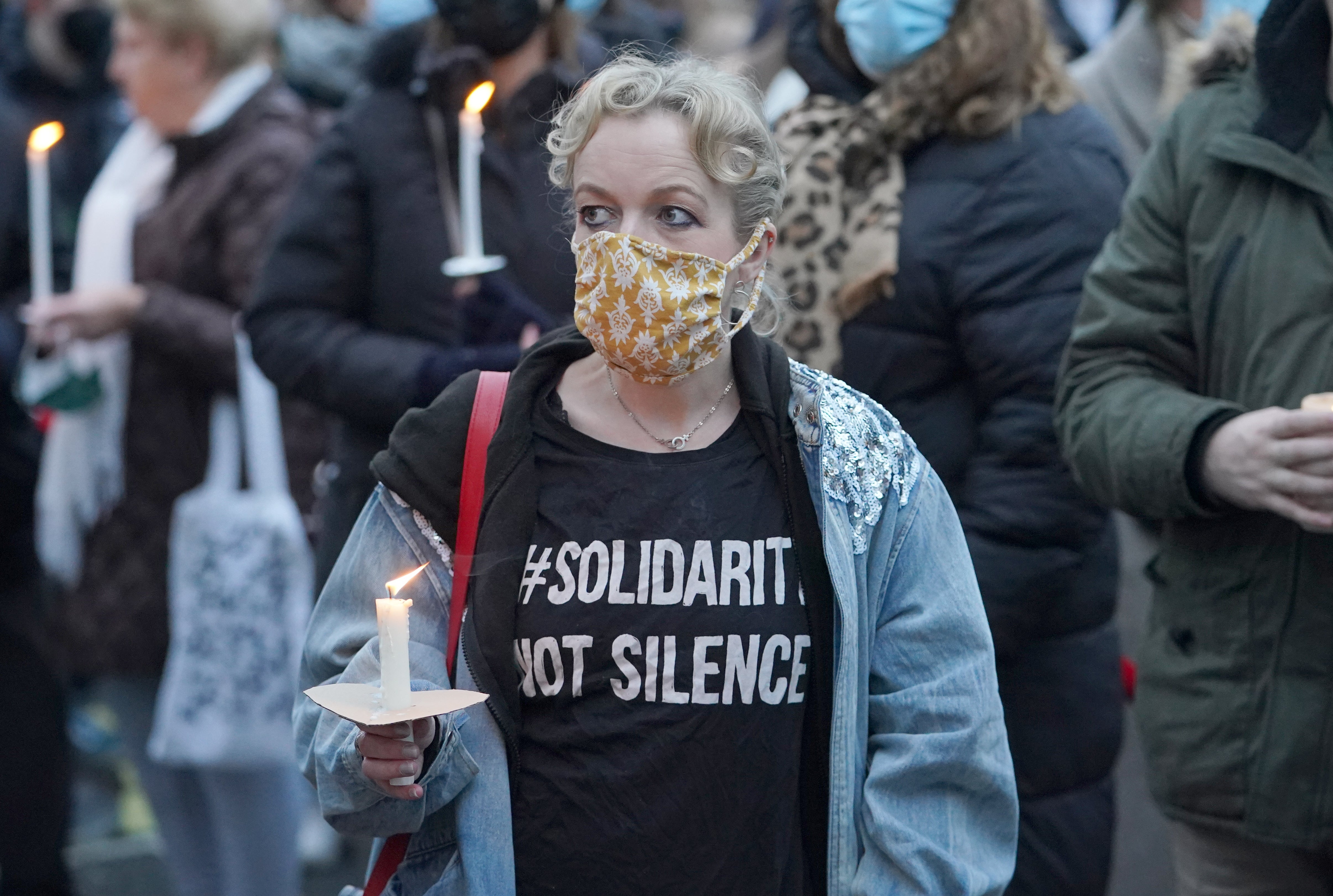 A woman wearing a ‘solidarity, not silence, T-shirt attends a vigil outside the London Irish Centre in Camden (PA)