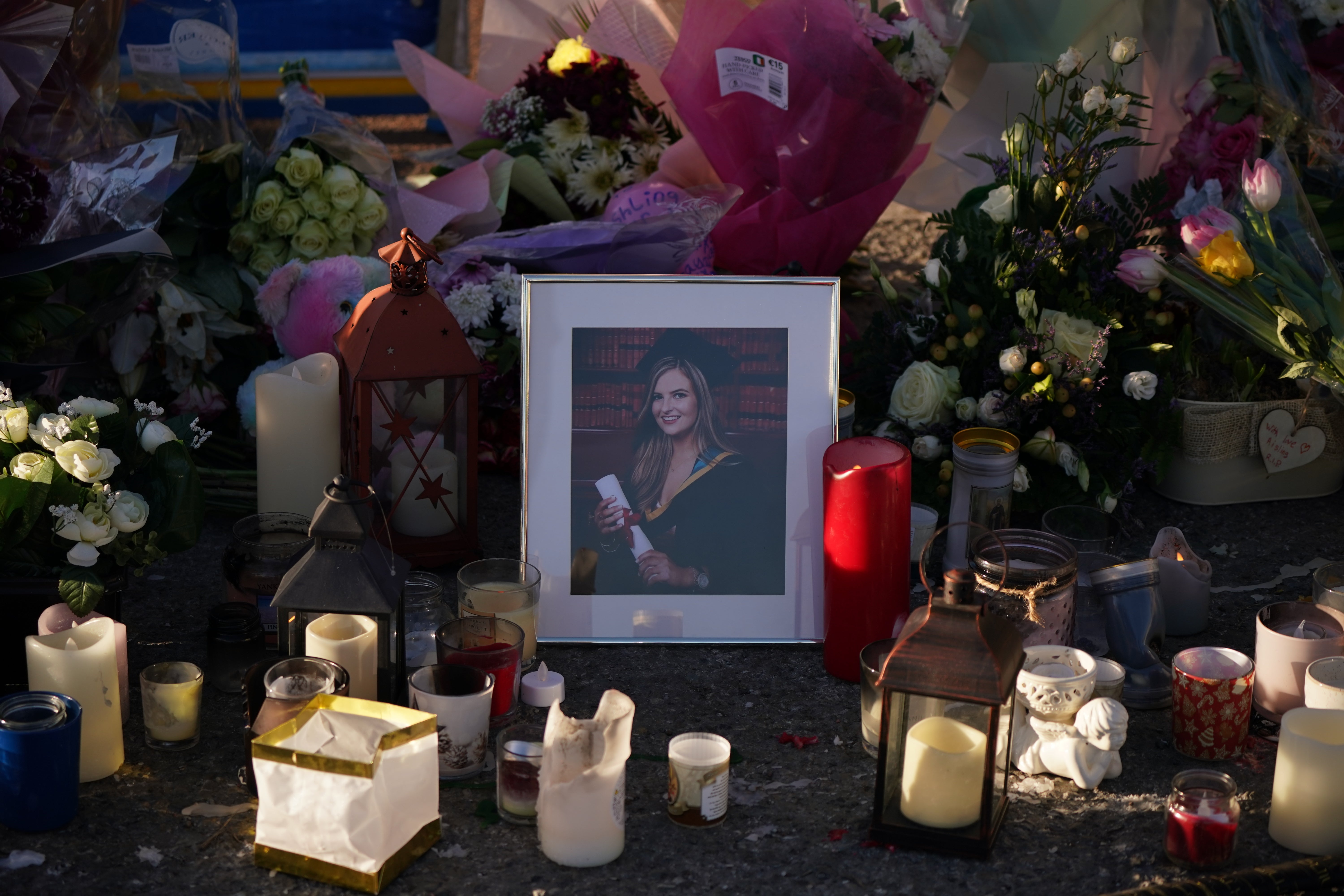 Floral tributes and candles surround a photograph left at the Grand Canal in Tullamore, Co Offaly, where primary school teacher Ashling Murphy was found dead after going for a run (Niall Carson/PA)