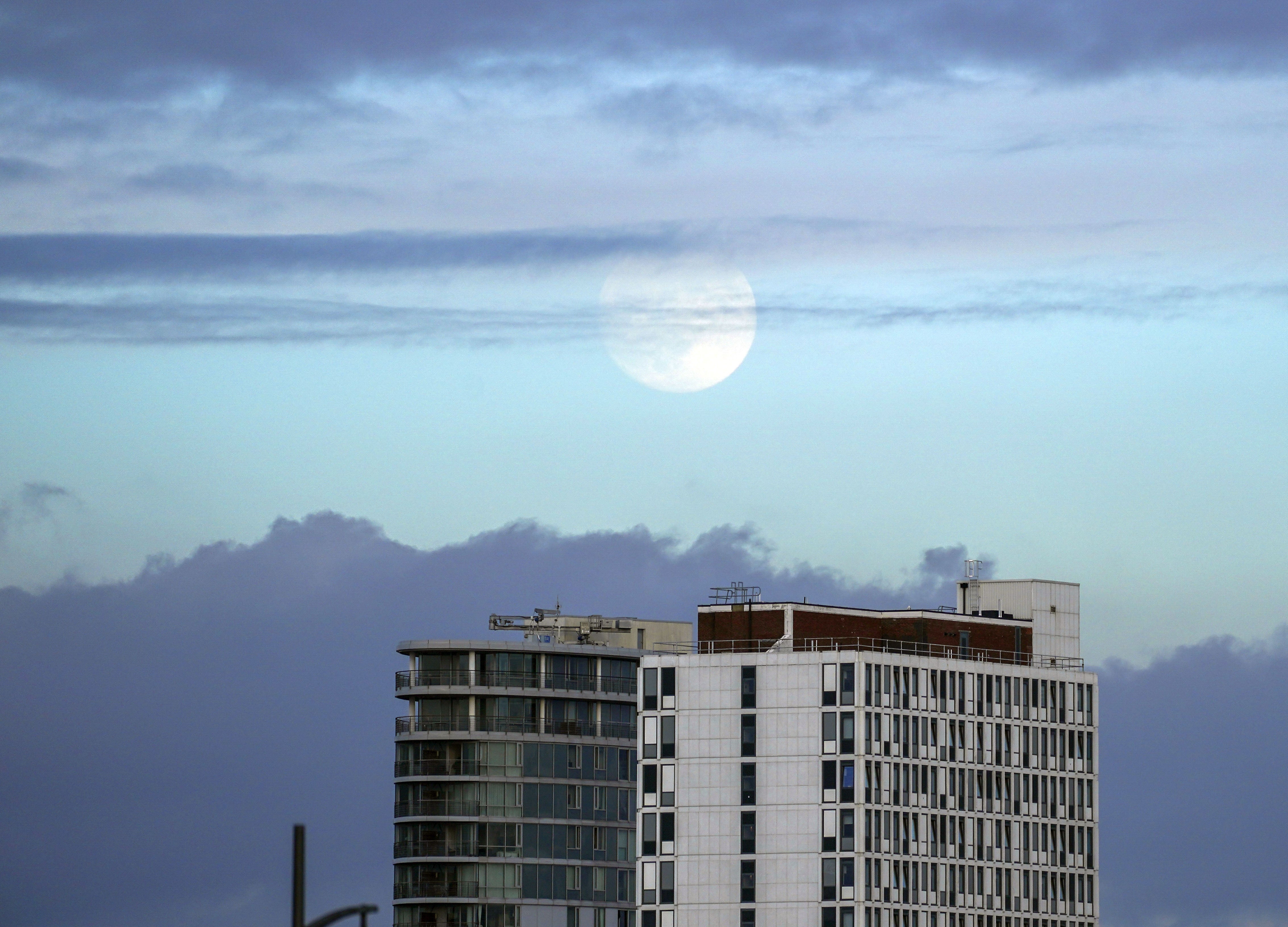 The moon rises above a tower block in Portsmouth