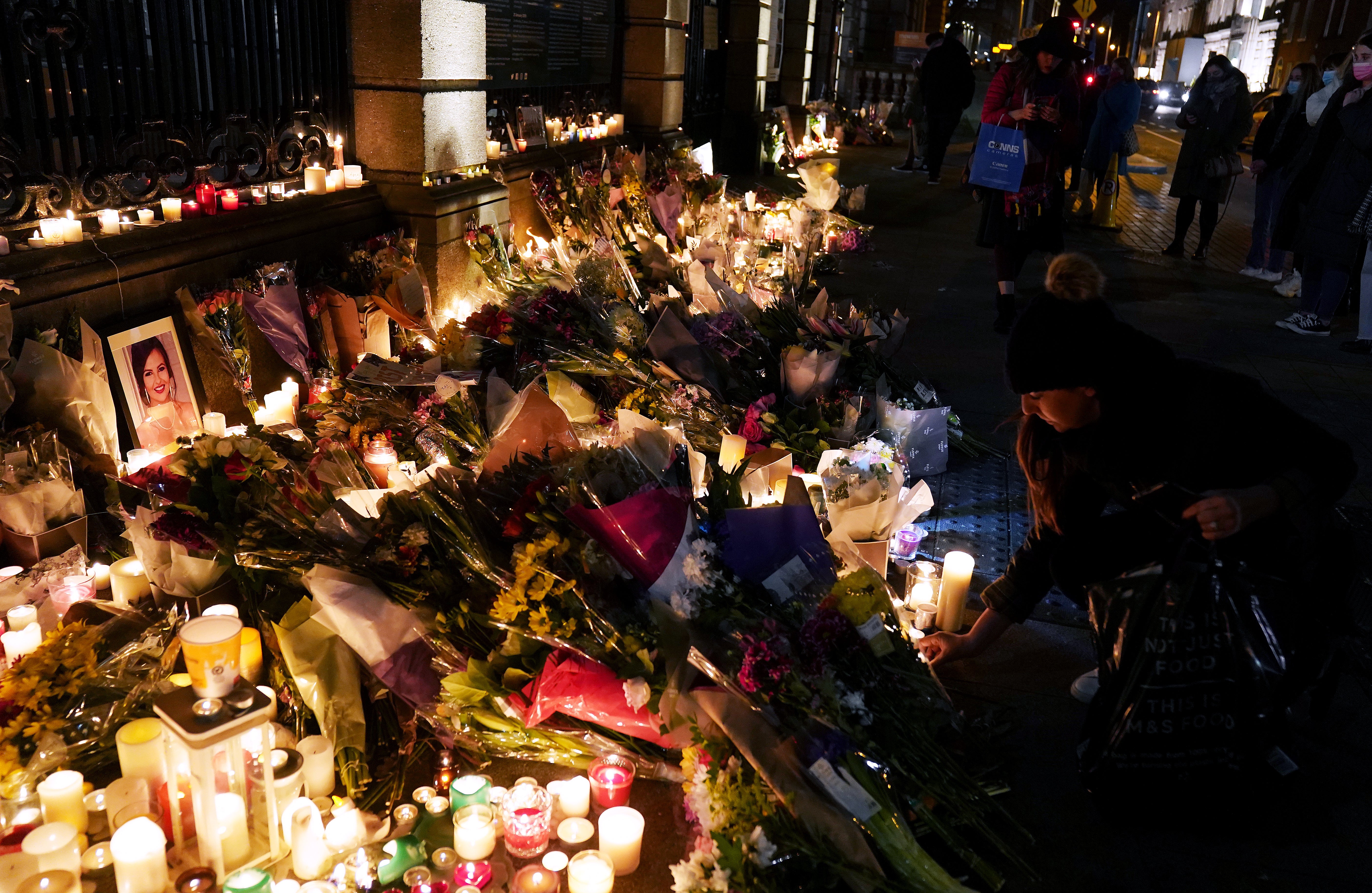 People leave candles and flowers at a make-shift shrine during a vigil at Leinster House, Dublin, for the murdered Ashling Murphy who died after being attacked while she was jogging along the Grand Canal in Tullamore, County Offaly, on Wednesday (Brian Lawless/PA)