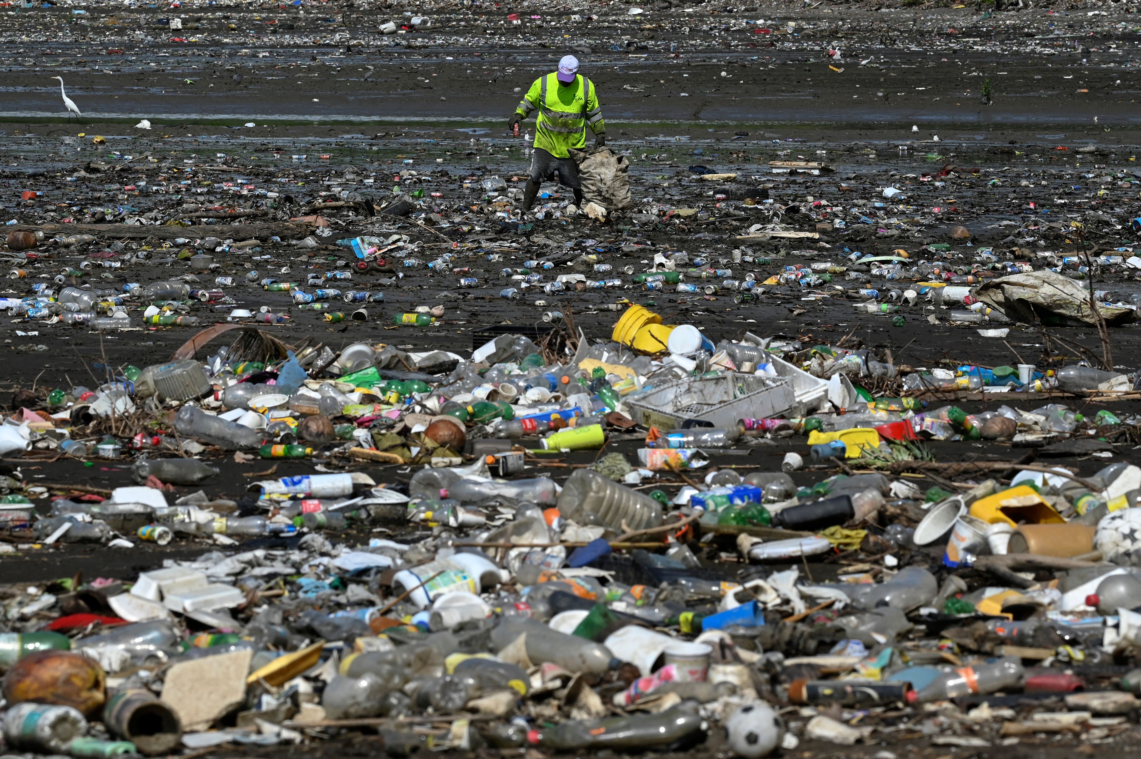 A man collects garbage, including plastic waste, at the beach of Costa del Este, in Panama City, on 19 April