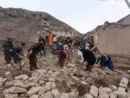 Rescue workers look through debris in the aftermath of two successive earthquakes in Badghis province of Afghanistan