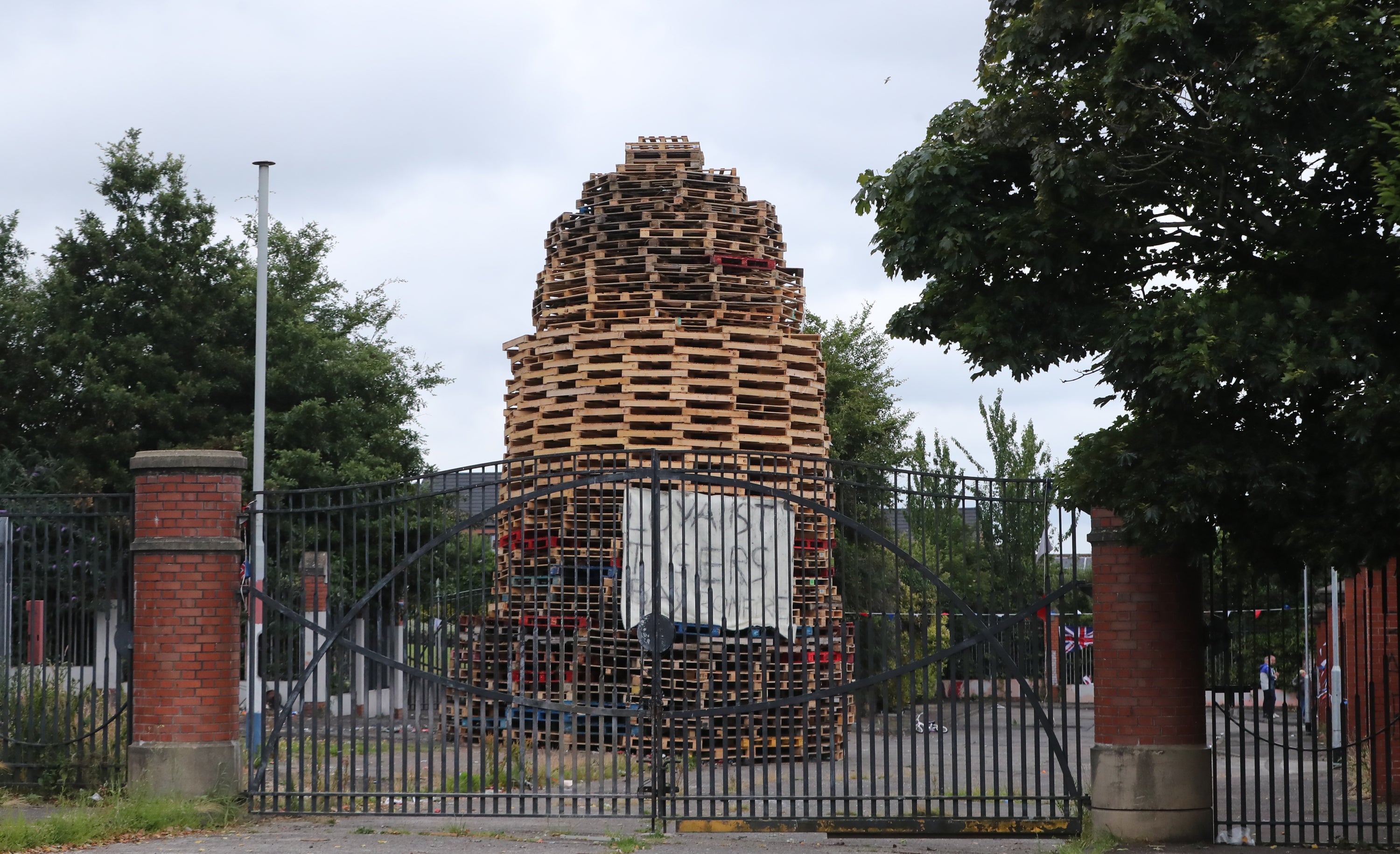 A controversial bonfire is built next to a peace wall between the loyalist Tiger’s Bay and the nationalist New Lodge area of Belfast (Niall Carson/PA)