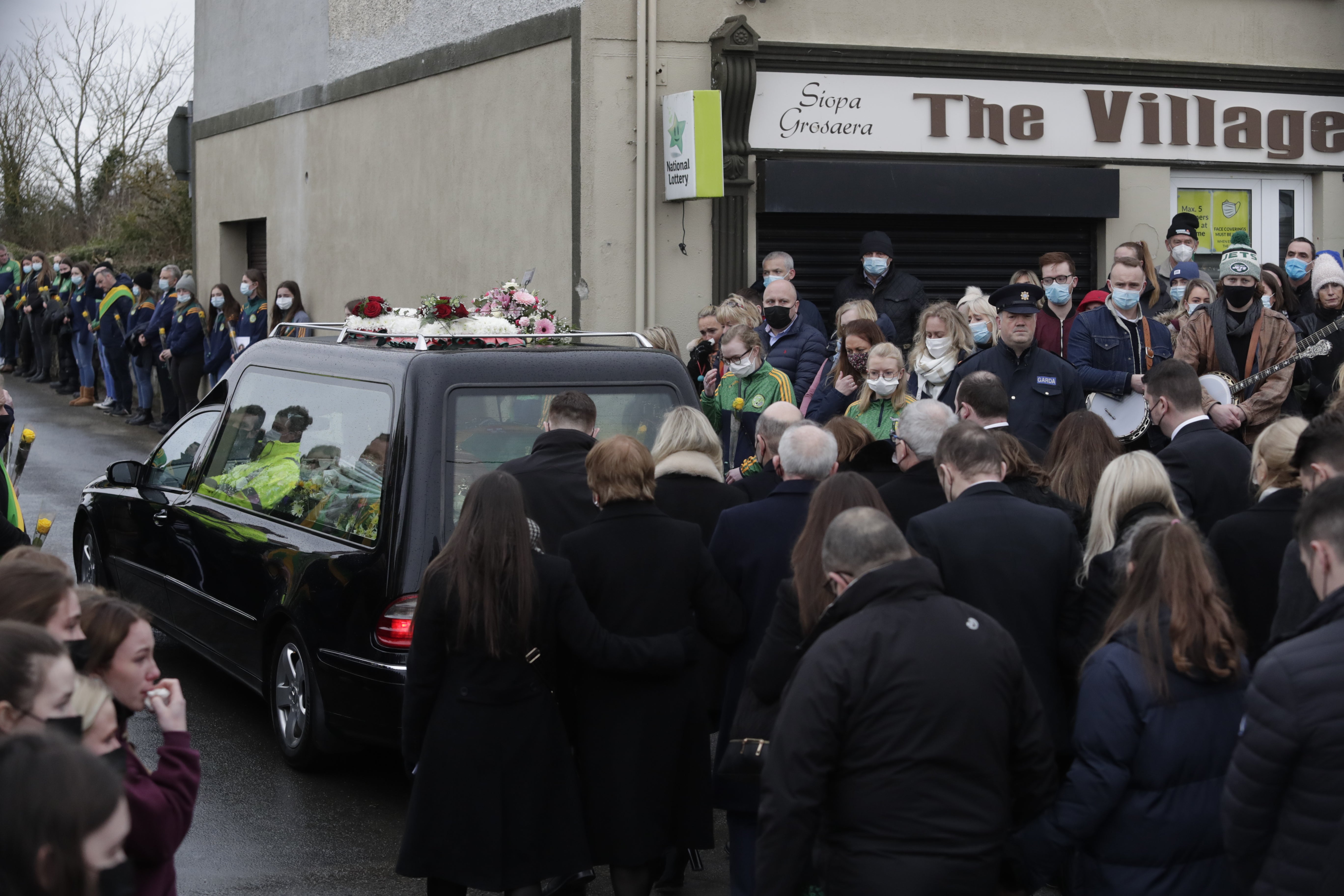 Mourners walk behind he hearse carrying the coffin as it leaves St Brigid’s Church (Damien Eagers/PA)