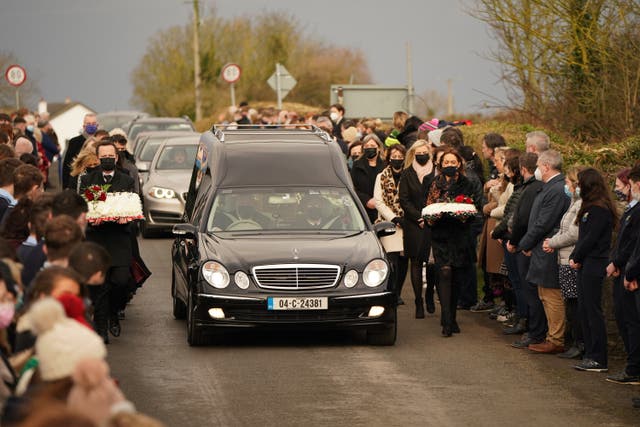 Mourners walk beside the hearse as the cortege arrives at St Brigid’s Church, Mountbolus, Co Offaly (Niall Carson/PA)