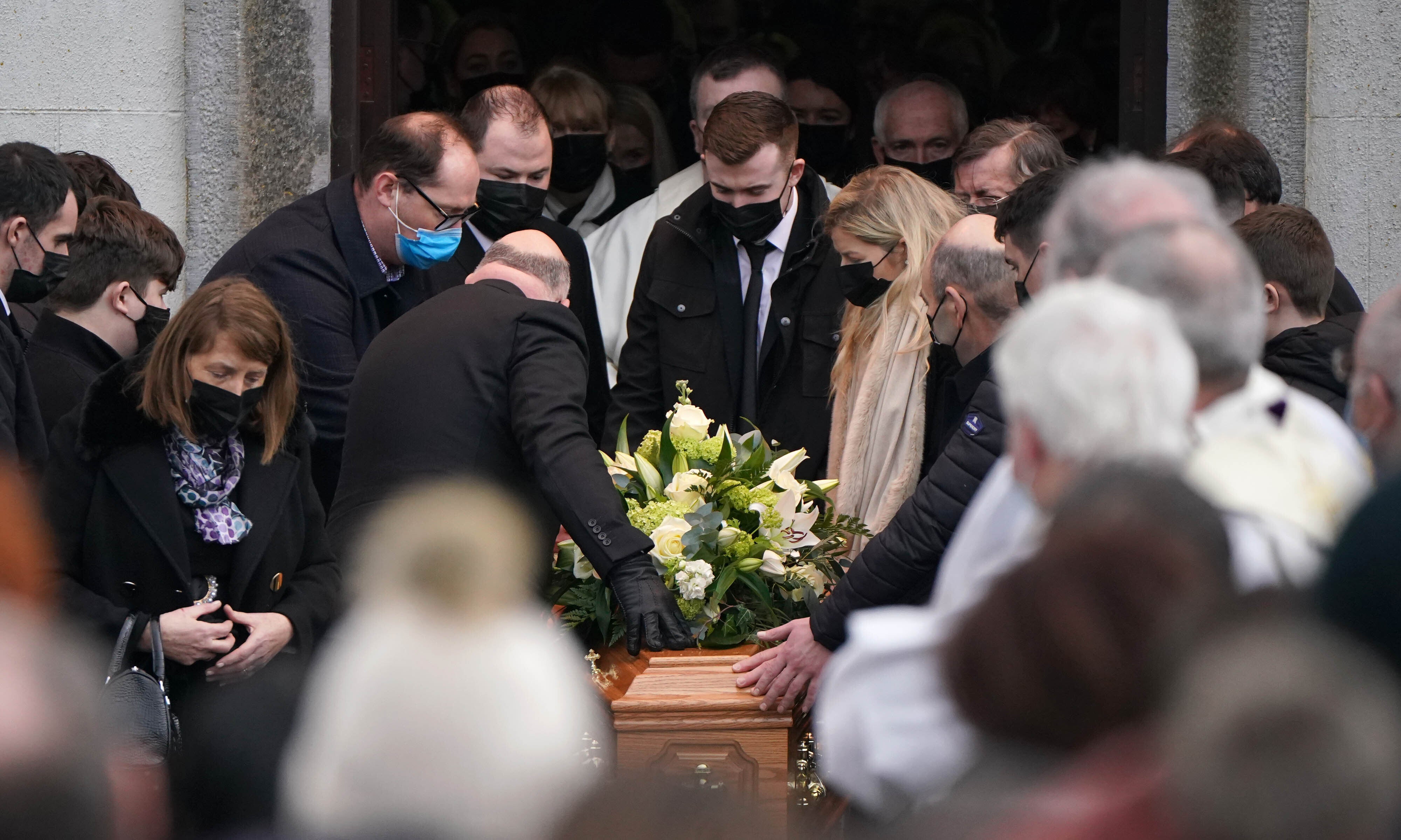 Family members place their hands on the coffin as it is carried out of St Brigid’s Church, Mountbolus, Co Offaly, after the funeral of Ashling Murphy(Niall Carson/PA)