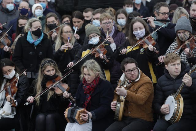 Traditional Irish musicians play outside St Brigid’s Church, Mountbolus, Co Offaly, at the end of the funeral of Ashling Murphy (PA)