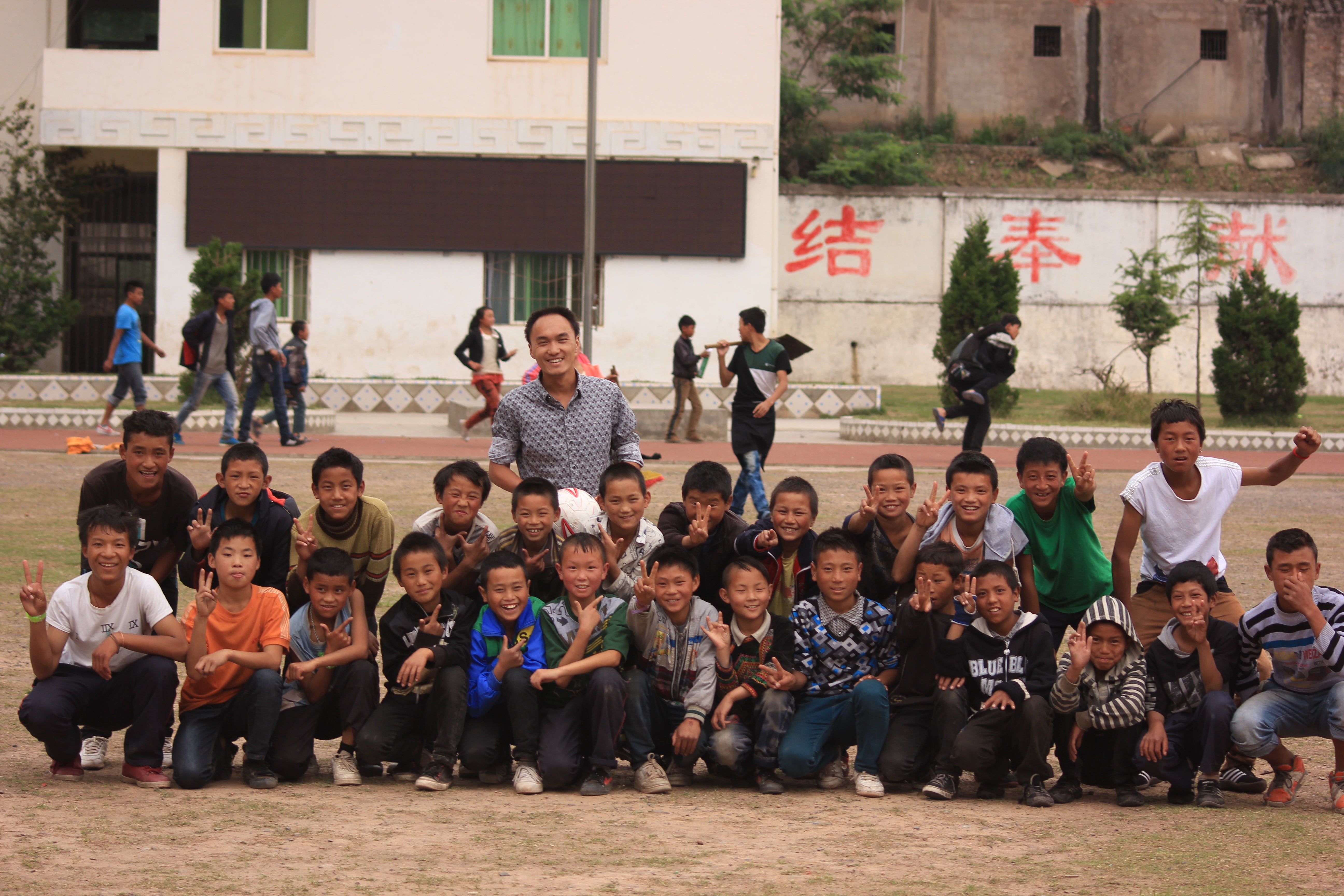 Volunteer teacher Liu Yelong with his students at Daqiao Junior Middle School in Meigu county, Liangshan Yi autonomous prefecture, Sichuan province