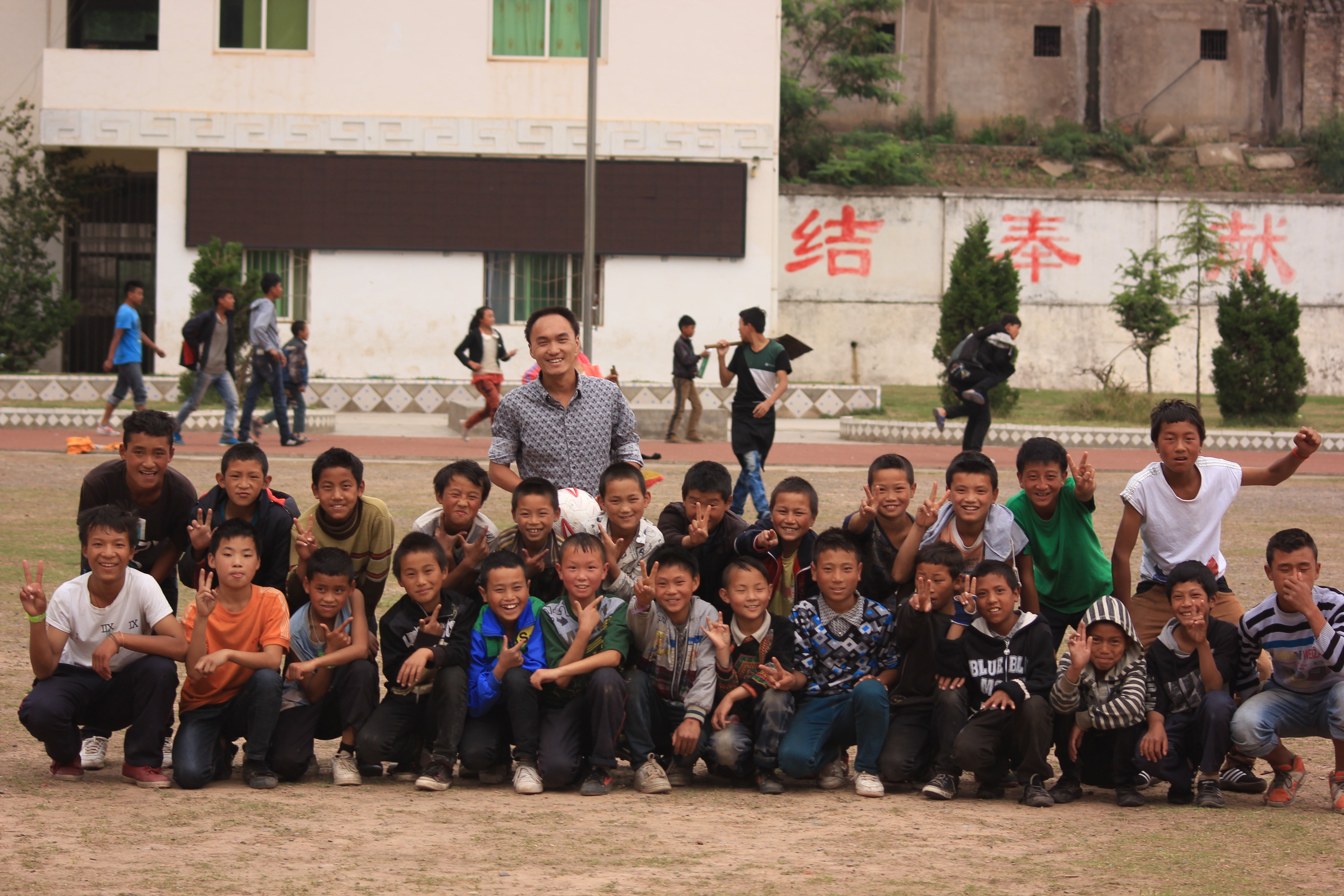 Volunteer teacher Liu Yelong with his students at Daqiao Junior Middle School in Meigu county, Liangshan Yi autonomous prefecture, Sichuan province