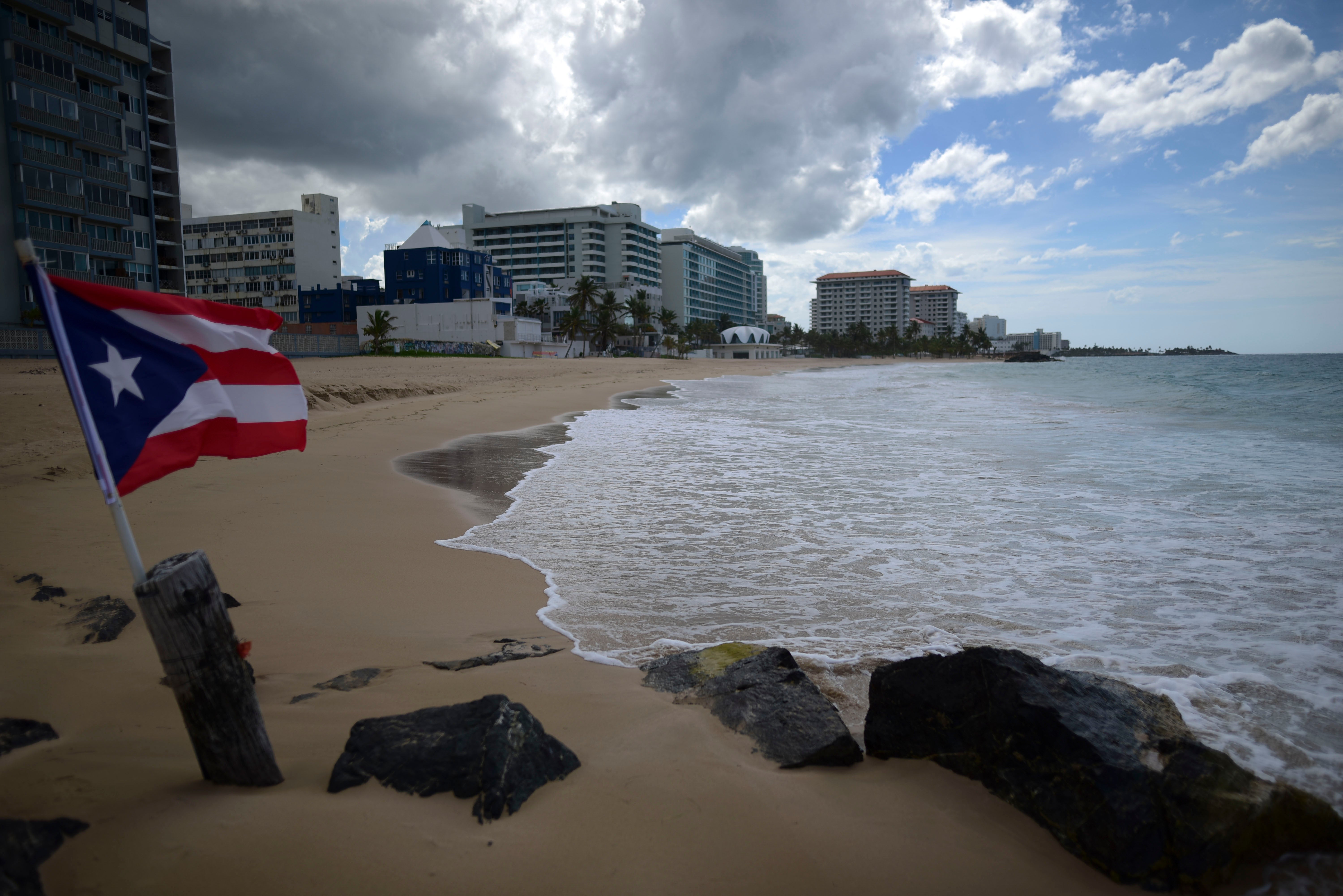 A Puerto Rican flag on an empty beach at Ocean Park, San Juan, Puerto Rico (stock image) There have been eight drowning deaths at Puerto Rican beaches in 2024