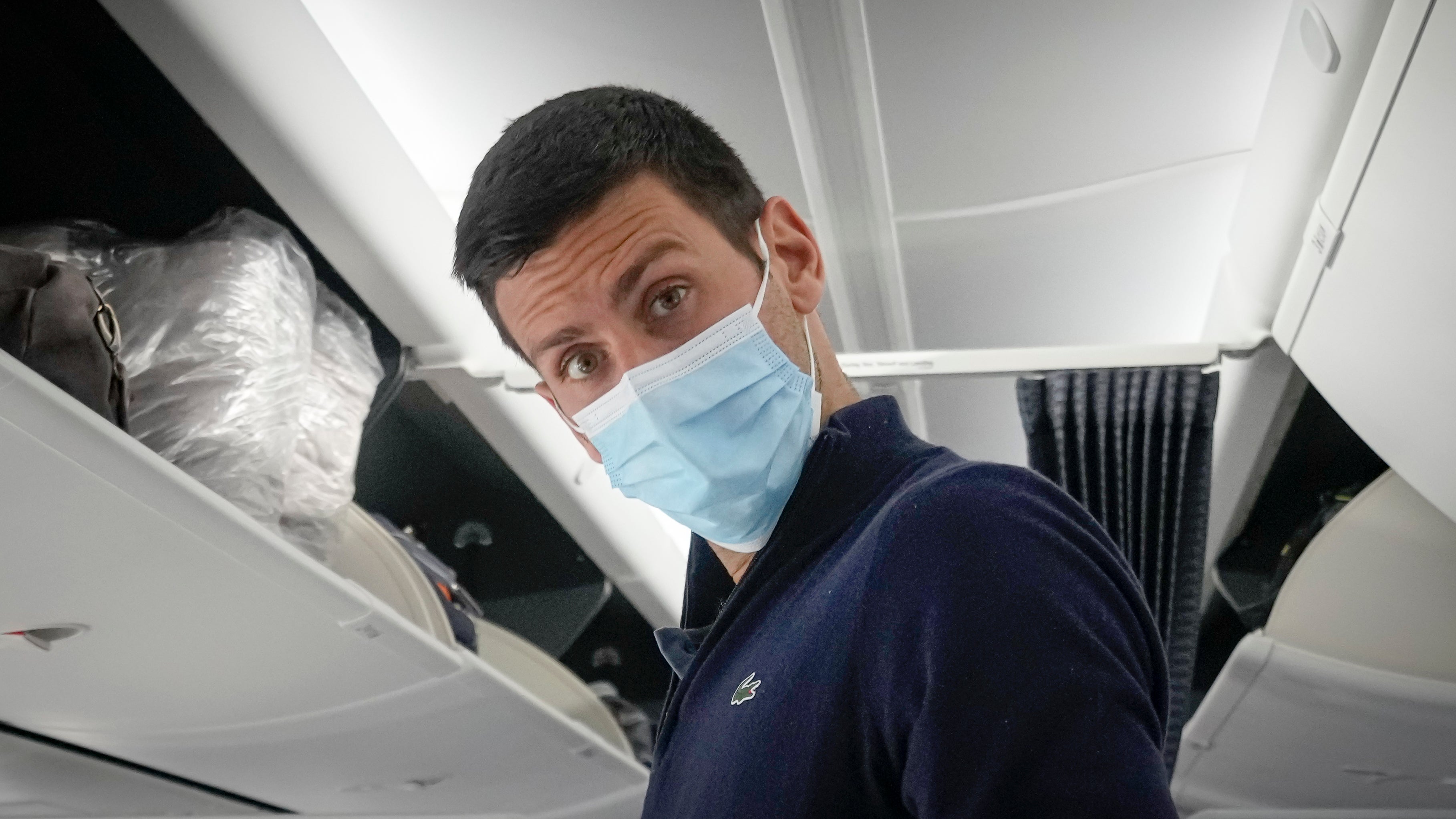 File photo: Novak Djokovic prepares to take his seat on a plane to Belgrade, in Dubai, United Arab Emirates,17 January 2022