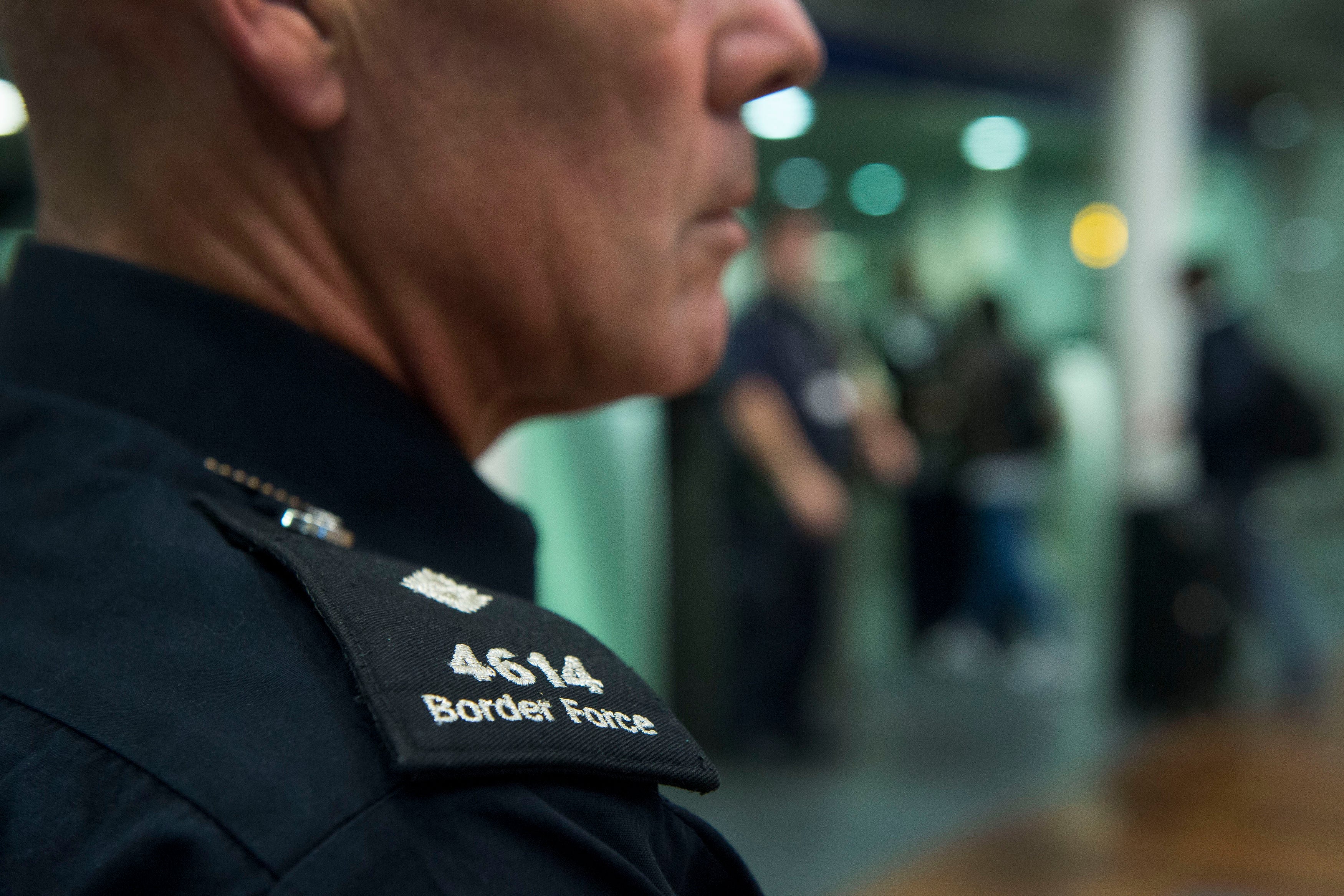 A UK Border Force officer watches over passengers arriving from Paris on the Eurostar