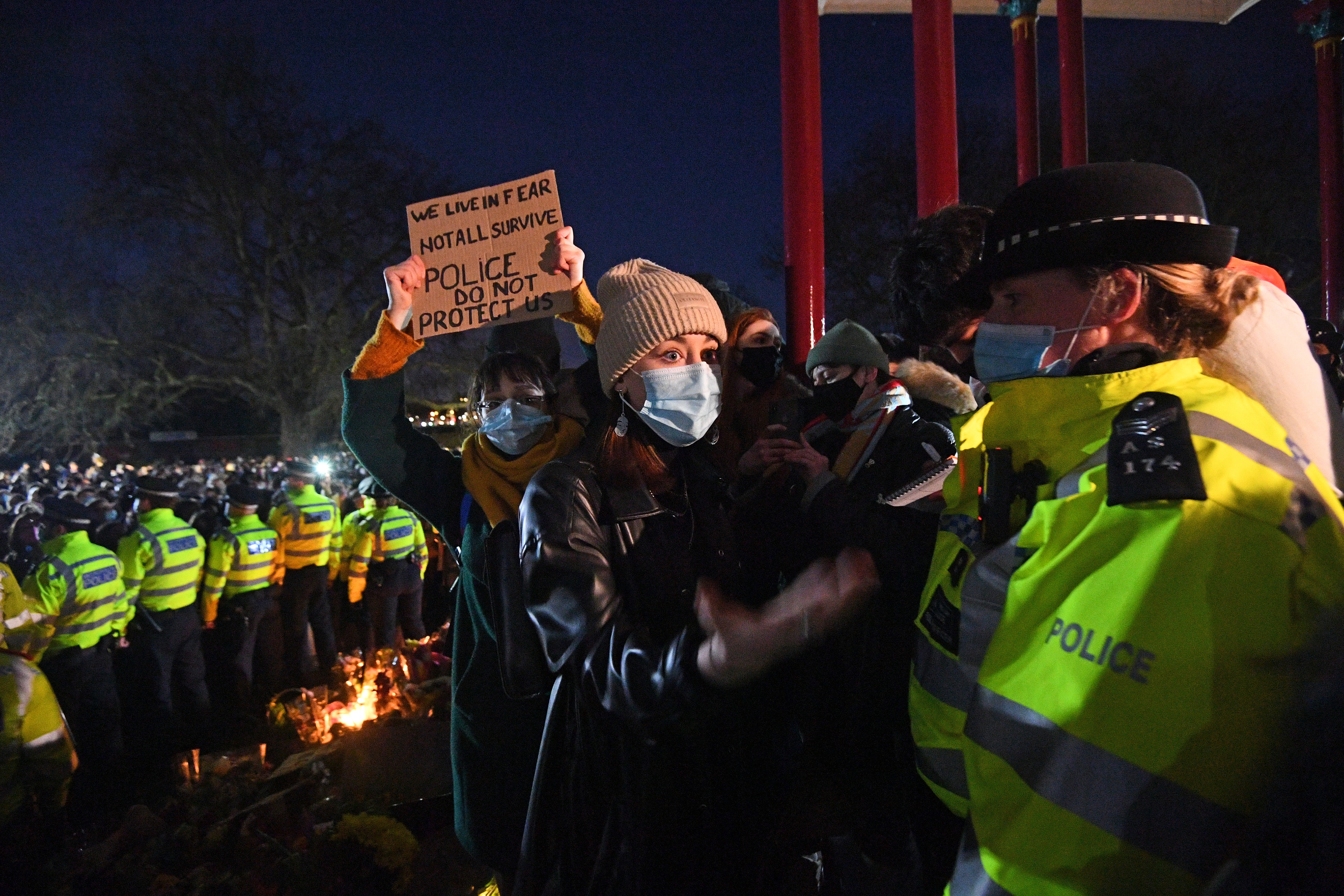 A woman holds up a placard at the bandstand in Clapham Common (Victoria Jones/PA)