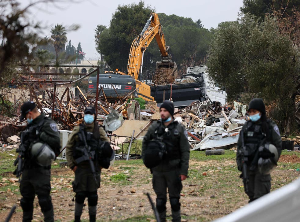 <p>Israeli forces stand guard as machinery clean the ruins of the Palestinian Salhiya family’s house, in the Sheikh Jarrah neighbourhood</p>