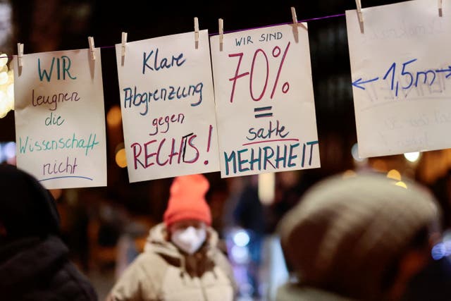 <p>Signs are hung as people attend a counter-protest during a demonstration against government measures to curb the spread of the coronavirus disease (Covid-19), in front of Gethsemane church in Berlin</p>