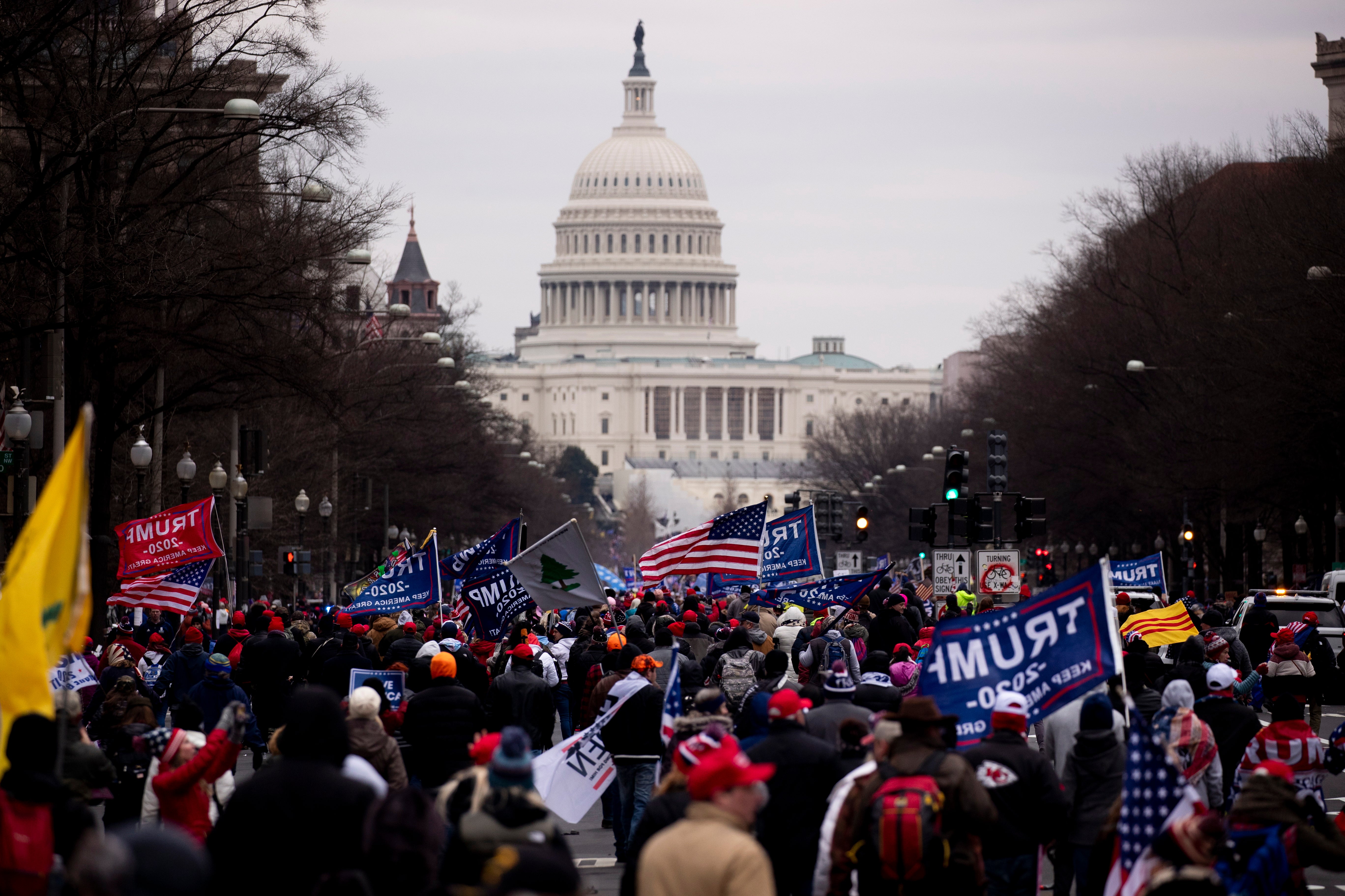 Pro-Trump protesters march down Pennsylvania Avenue to the US Capitol (seen behind) in Washington, DC, 6 January 2021