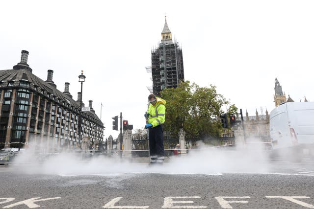 A street cleaner washes glue off the road outside the Palace of Westminster (James Manning/PA)