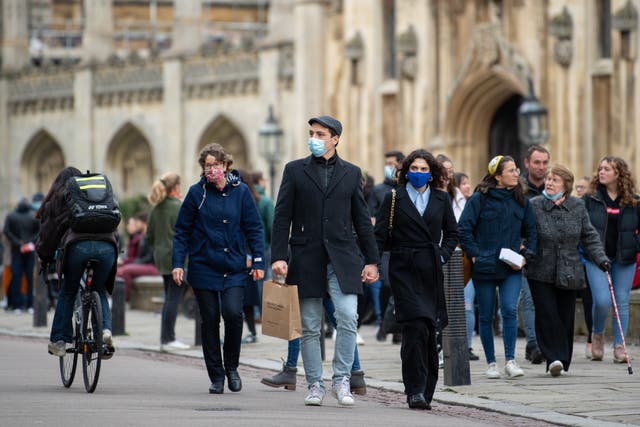 People wear face masks as they walk along Kings Parade in Cambridge (Joe Giddens/PA)