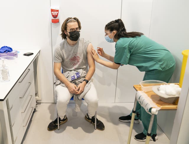 Simran Saughall administers a booster vaccine to Adam Hamilton at a Covid vaccination centre at Elland Road in Leeds (Danny Lawson/PA)