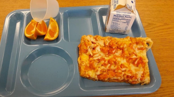 A slice of pizza with three orange slices is served for lunch at one upstate New York school