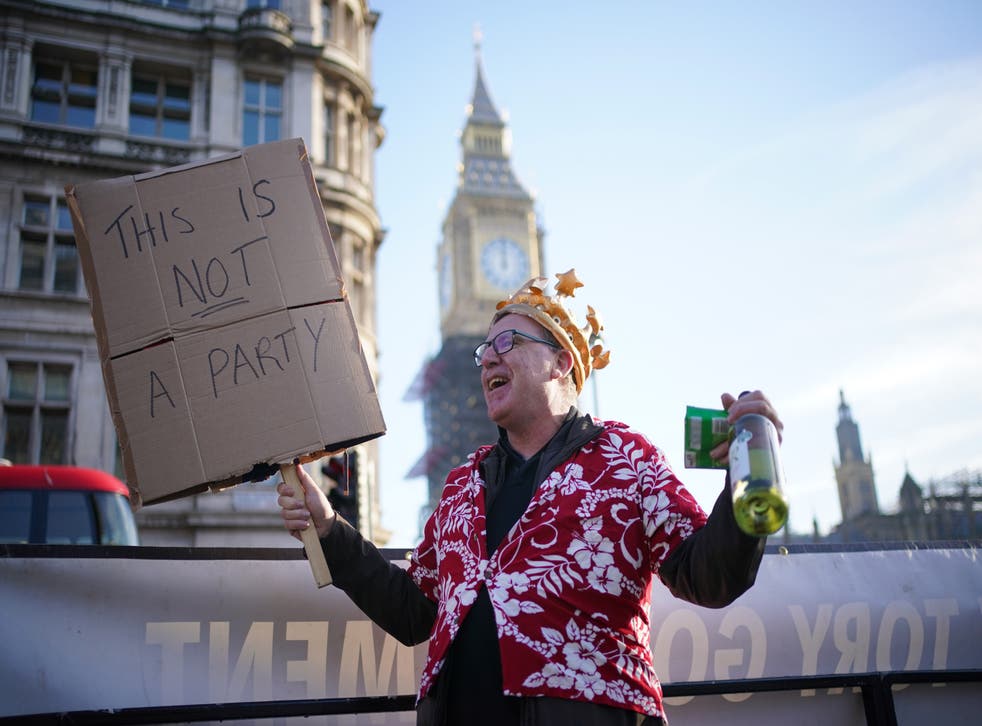 A protestor in Parliament Square demonstrating against Downing St parties (Dominic Lipinski/PA)