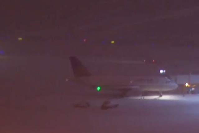 <p>An aeroplane sits on the snow at RDU, shortly after the Delta flight skidded off the runway. </p>