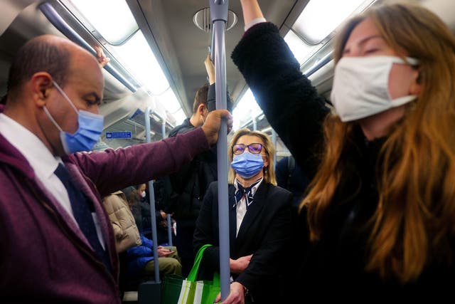 <p>Commuters on the Tube wearing Covid face masks </p>