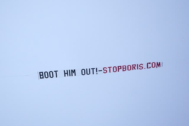 A sign protesting against Prime Minister Boris Johnson is flown over Manchester United’s Premier League match with West Ham at Old Trafford, Manchester (PA)