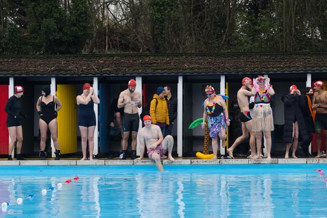 Participants prepare to take part in the Crisis icebreaker cold water challenge at Tooting Bec Lido in London